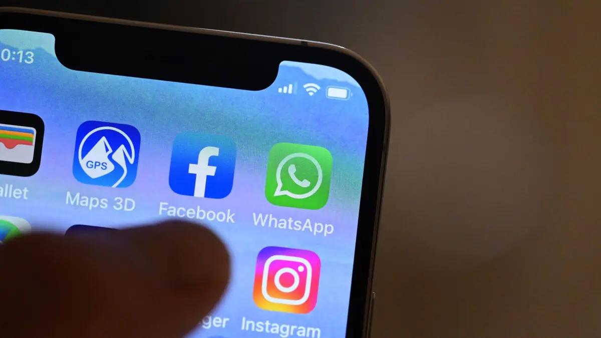 ILLUSTRATION - Eine Hand hält ein iPhone, auf dem Sozial Media Apps dargestellt sind (gestellte Szene). Am 10. Februar gibt der Datenschutzbeauftragte des Landes Baden-Württemberg seinen Tätigkeitsbericht Datenschutz 2022 bekannt. +++ dpa-Bildfunk +++