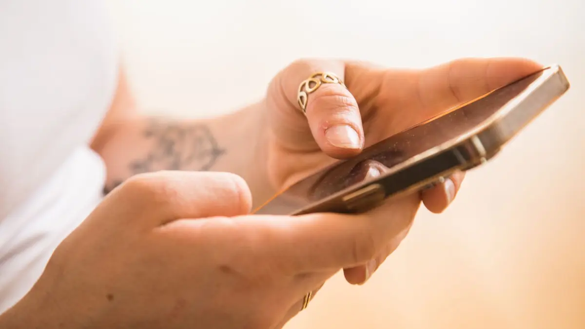 Frau mit Smartphone: ILLUSTRATION - Bei sogenannten Ping-Calls lassen Betrüger das Handy kurz anklingeln, legen dann sofort auf und versuchen so Leute dazu zu bringen, dass sie zurückrufen. (zu dpa: «Anruf aus dem Ausland: Vorsicht bei diesen Vorwahlen») Foto: Christin Klose/dpa-tmn - Honorarfrei nur für Bezieher des dpa-Themendienstes +++ dpa-Themendienst +++