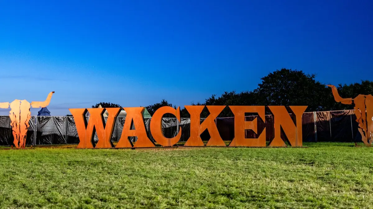 30.07.2024, Schleswig-Holstein, Wacken: Das Festival-Logo gefertigt aus großen Metallbuchstaben, steht auf einer Wiese. Das WOA gilt als größtes Heavy-Metal-Festival der Welt. Foto: Axel Heimken/dpa +++ dpa-Bildfunk +++