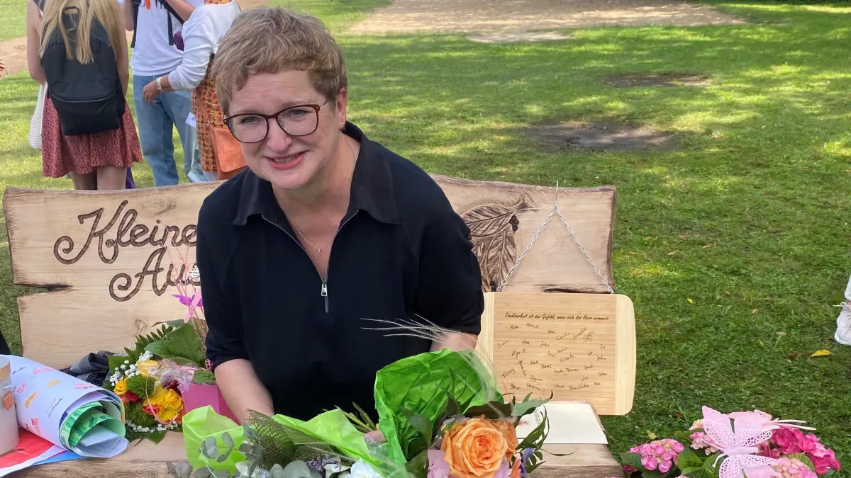 Martina Werner auf ihrer neuen Gartenbank: Die langjährige Leiterin der Schönfließer Grundschule ist vom stimmungsvollen Abschiedsprogramm ihrer Kollegen und Schüler noch überwältigt.