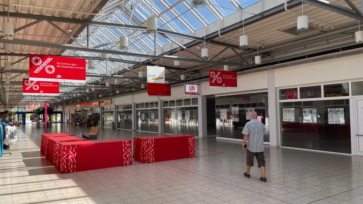 Im City Center bieten Geschäfte gerade einen "Summer-Sale" mit Schnäppchen an. Währenddessen laufen auf einer Ladenfläche die Vorbereitungen für die Neueröffnung eines Filialisten.