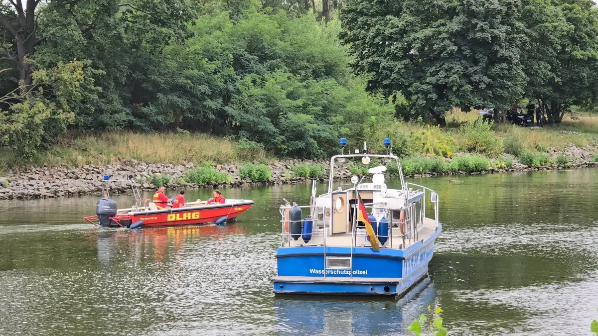 Leiche im Silokanal in Brandenburg gefunden: 18.08.2024, Brandenburg, Brandenburg an der Havel: In Brandenburg/Havel fahren Boote der Wasserschutzpolizei und der DLRG auf dem Silokanal, nachdem hier eine Leiche gefunden wurde. Unklar war, ob es sich um ein Verbrechen handelt. Nach einem Bericht der «Märkischen Allgemeinen» schwimmt der leblose Körper noch im Wasser. Die die Polizei hat den Uferweg am Silokanal abgesperrt. Foto: Cevin Dettlaff/dpa +++ dpa-Bildfunk +++