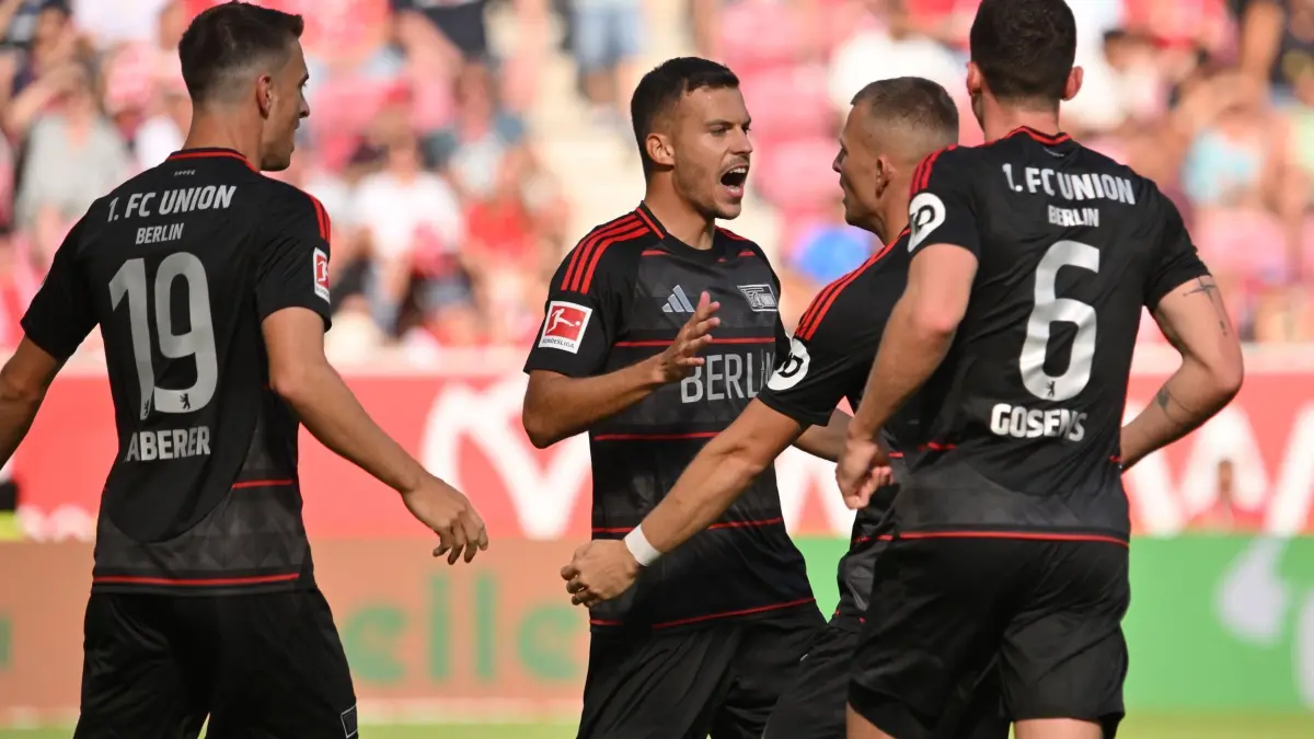 FSV Mainz 05 - 1. FC Union Berlin: 24.08.2024, Rheinland-Pfalz, Mainz: Fußball, Bundesliga, FSV Mainz 05 - 1. FC Union Berlin, 1. Spieltag, Mewa Arena. Unions Laszlo Benes (2.v.l.) jubelt nach seinem Treffer zum 1:1 mit Unions
Janik Haberer (l) und Robin Gosens (r). Foto: Torsten Silz/dpa - WICHTIGER HINWEIS: Gemäß den Vorgaben der DFL Deutsche Fußball Liga bzw. des DFB Deutscher Fußball-Bund ist es untersagt, in dem Stadion und/oder vom Spiel angefertigte Fotoaufnahmen in Form von Sequenzbildern und/oder videoähnlichen Fotostrecken zu verwerten bzw. verwerten zu lassen. +++ dpa-Bildfunk +++