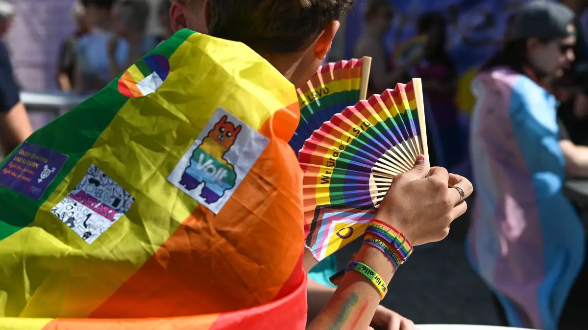 Christopher Street Day - Magdeburg: 24.08.2024, Sachsen-Anhalt, Magdeburg: Teilnehmer mit Regenbogen- und einer Transfahne ziehen beim Christopher Street Day (CSD) durch die Innenstadt. Für Vielfalt und Toleranz gehen Tausende Menschen auf die Straße. Foto: Heiko Rebsch/dpa +++ dpa-Bildfunk +++
