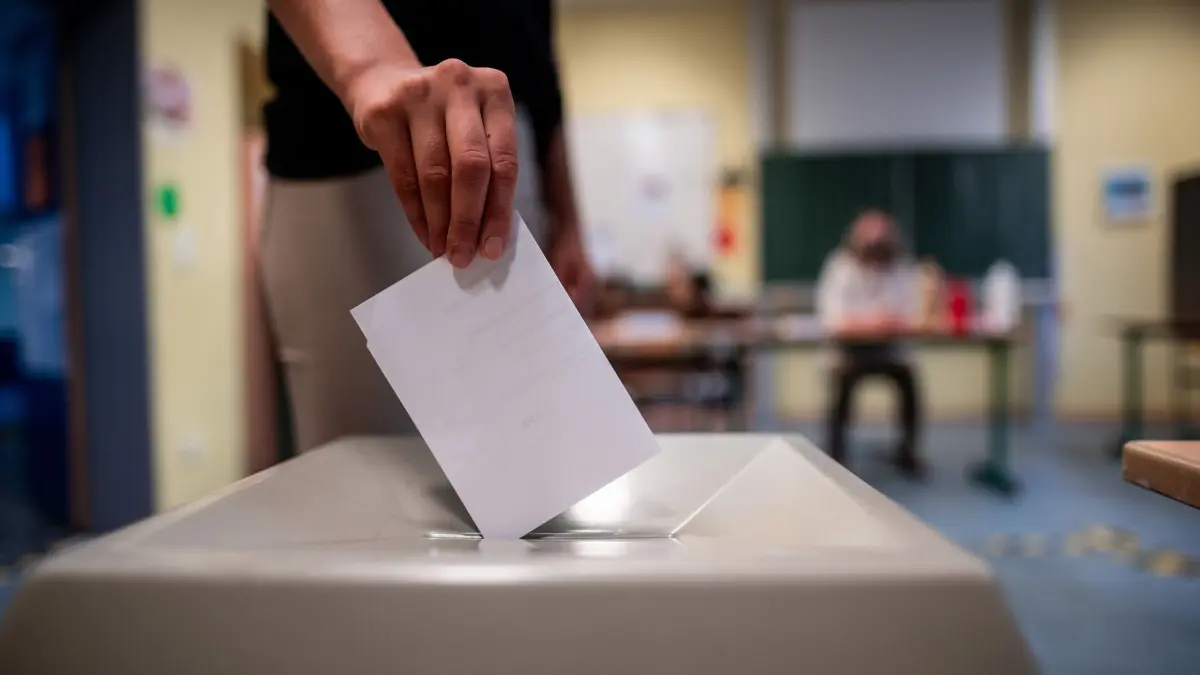 Wahlurne: ARCHIV - 27.09.2020, Nordrhein-Westfalen, Düsseldorf: Eine Frau wirft einen Wahlschein in eine Wahlurne. Gut ein Jahr vor den Kommunalwahlen in Nordrhein-Westfalen ist ein Streit um ein von den Regierungsfraktionen CDU und Grüne geändertes Berechnungsverfahren entbrannt. (zu dpa: «Steuern, Wahlen, Corona-Hilfen: Das ändert sich im September») Foto: Fabian Strauch/dpa +++ dpa-Bildfunk +++