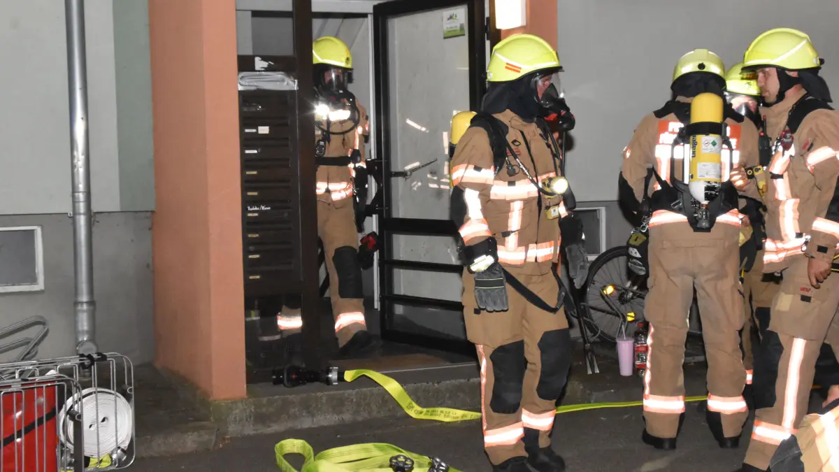 Brand in Fürstenwalde: Feuerwehrleute machen sich vor dem Brandhaus im Paul-Frost-Ring fertig für ihren Einsatz unter Atemschutz.