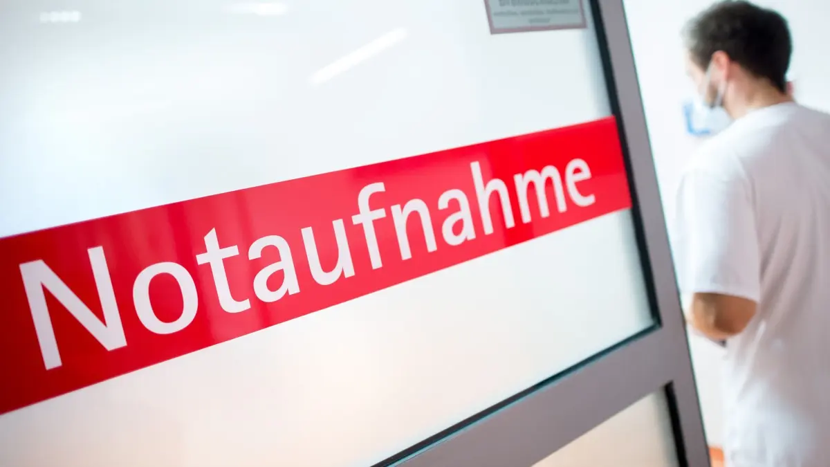 Notaufnahme: ARCHIV - 27.03.2018, Niedersachsen, Braunschweig: Ein Krankenpfleger steht in einem Krankenhaus neben einer Glastür mit der Aufschrift «Notaufnahme». (zu dpa: «Mehr vollstationäre Patienten in Bayerns Krankenhäusern») Foto: Hauke-Christian Dittrich/dpa +++ dpa-Bildfunk +++