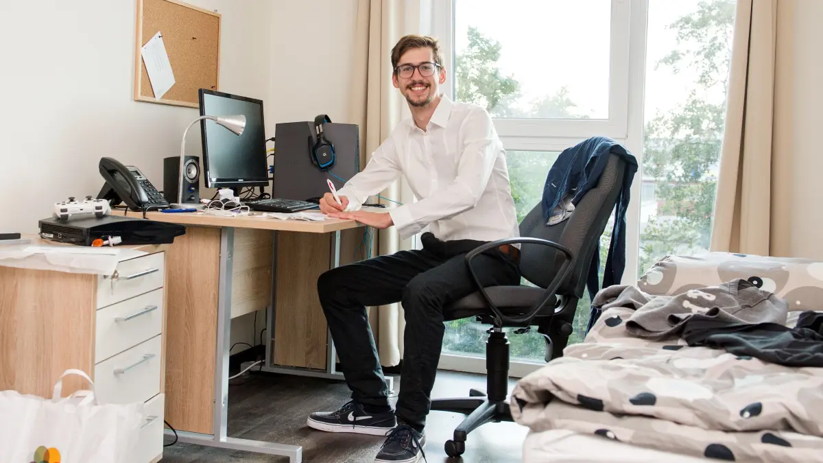 Ein Auszubildender sitzt in seinem Zimmer im Azubiwerk in Hamburg. In Schwedt soll nun auch eine Unterkunft für junge Auszubildende entstehen, die mit Einzel- und Doppelzimmern ausgestattet ist. Der Bedarf ist unerwartet groß.