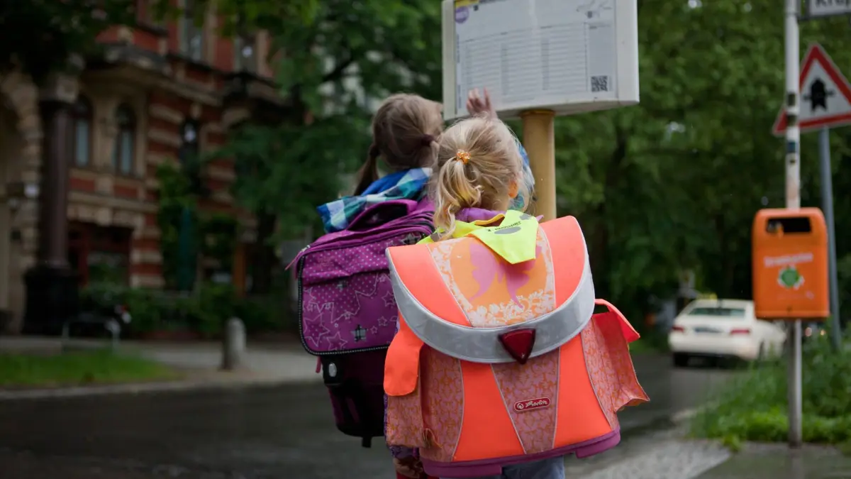 Kinder an der Bushaltestelle: ILLUSTRATION - Kinder sollten an der Haltestelle nicht Fangen spielen, herumrennen oder andere schubsen. (zu dpa: «So fahren Kinder sicher Bus») Foto: Silvia Marks/dpa-tmn - Honorarfrei nur für Bezieher des dpa-Themendienstes +++ dpa-Themendienst +++