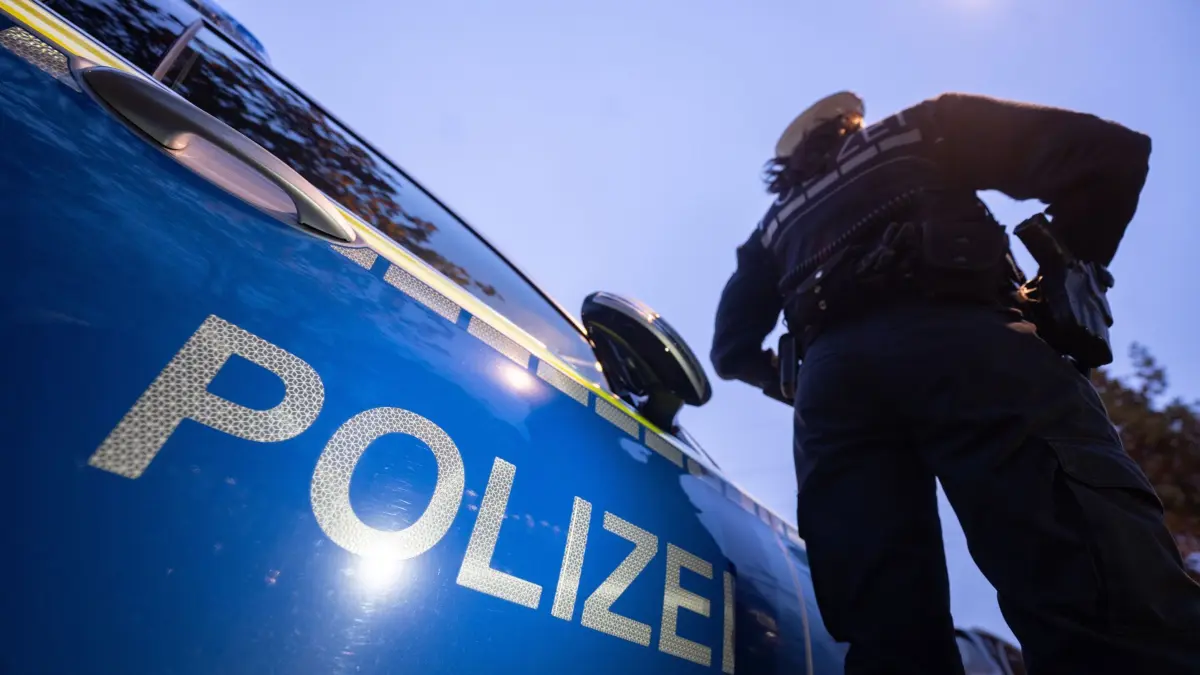 ILLUSTRATION - 30.11.2023, Baden-Württemberg, Stuttgart: Eine Polizistin steht neben einem Polizeifahrzeug. (zu dpa: «Mehr Körperverletzungen, mehr Raub, mehr Sexualstraftaten») Foto: Marijan Murat/dpa +++ dpa-Bildfunk +++