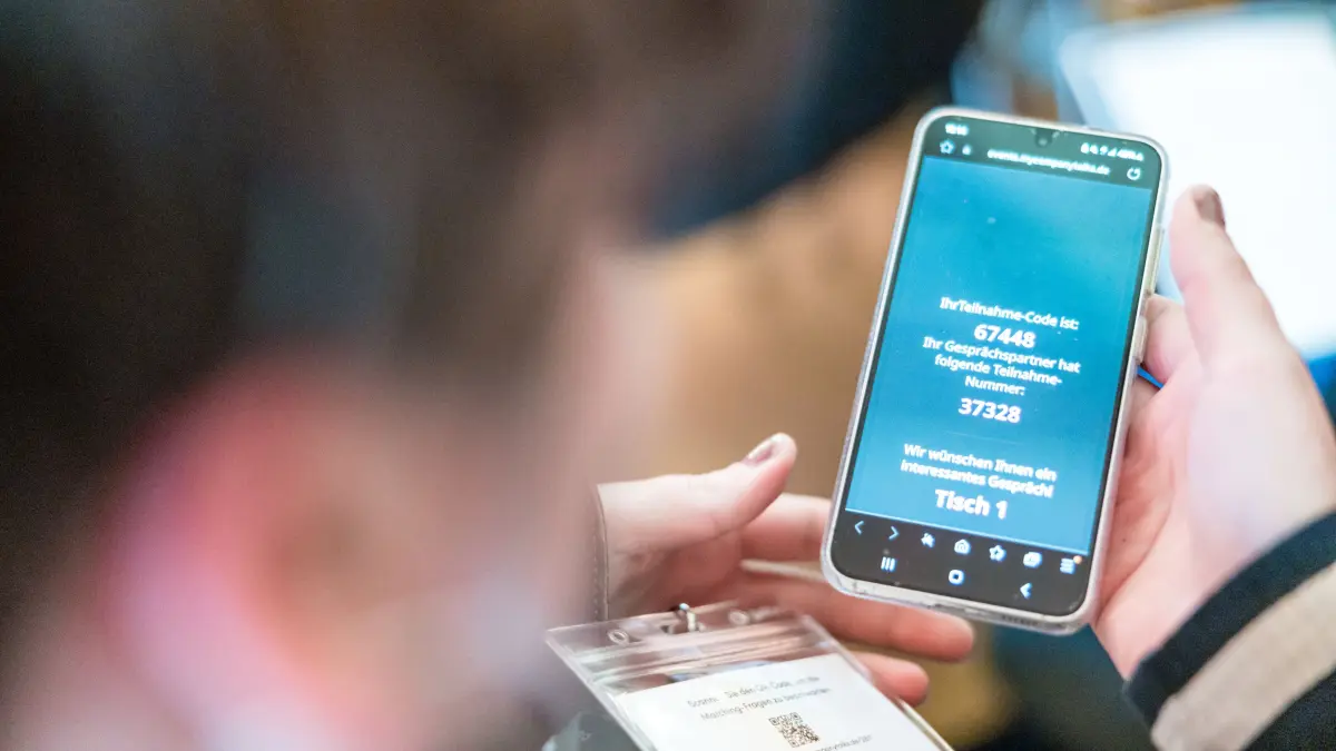 Deutschland spricht: Eine Frau schaut sich auf ihrem Smartphone das Ergebnis der Gesprächspartnersuche für die Gesprächsrunde «Deutschland spricht» an. ZEIT ONLINE lädt ins Alte Stadthaus in Cottbus ein, um mit Menschen vor Ort über die Frage zu diskutieren, was unsere Gesellschaft zusammenhält.