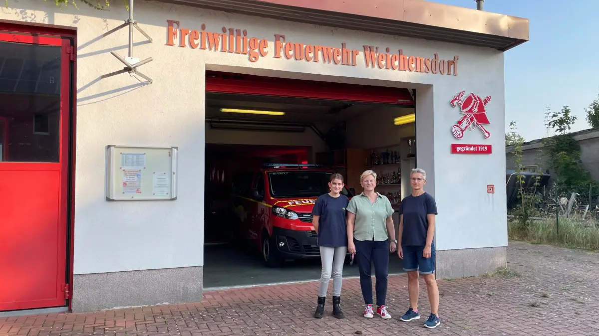 Stadtjugendwartin von Friedland Babett Schmidtchen (re) mit Jugendfeuerwehrkameradin Frieda (li) und deren Mutter vor dem Feuerwehrgerätehaus Friedland / Weichensdorf.
