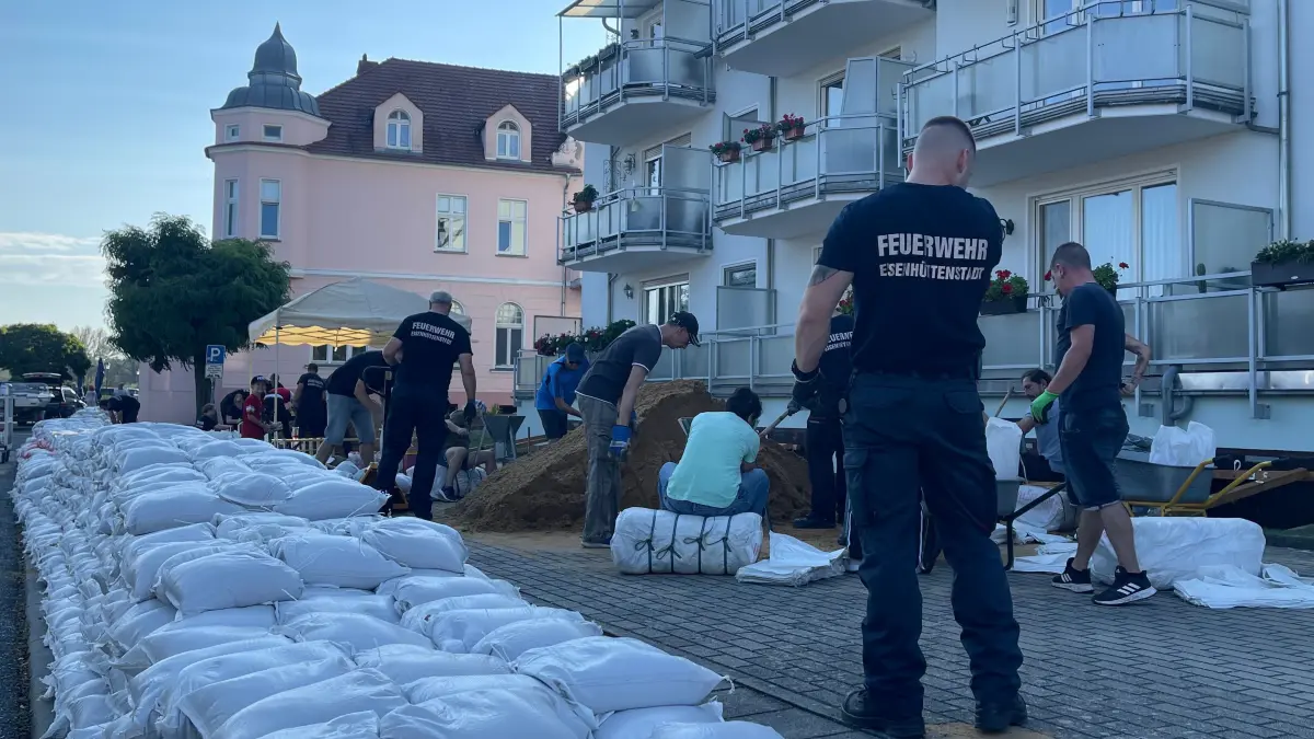 Mithilfe der Kameraden von der Eisenhüttenstädter Feuerwehr werden in der Straße Bollwerk im Ortsteil Fürstenberg Sandsäcke gefüllt und gestapelt.
