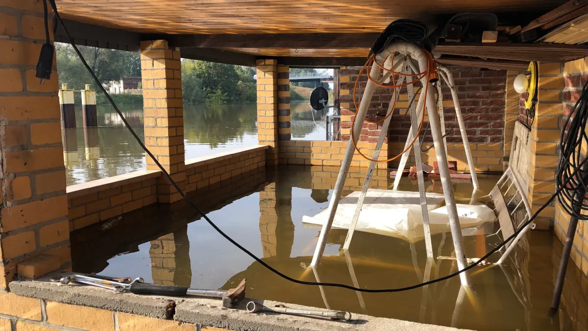 Hochwasser 2024-09-24: Fürstenberg/Oder, Ortsteil in Eisenhüttenstadt am 24.9.: die ersten Grundstücke und Straßen sind unter Wasser. Andreas Kainer macht sein Boot fest