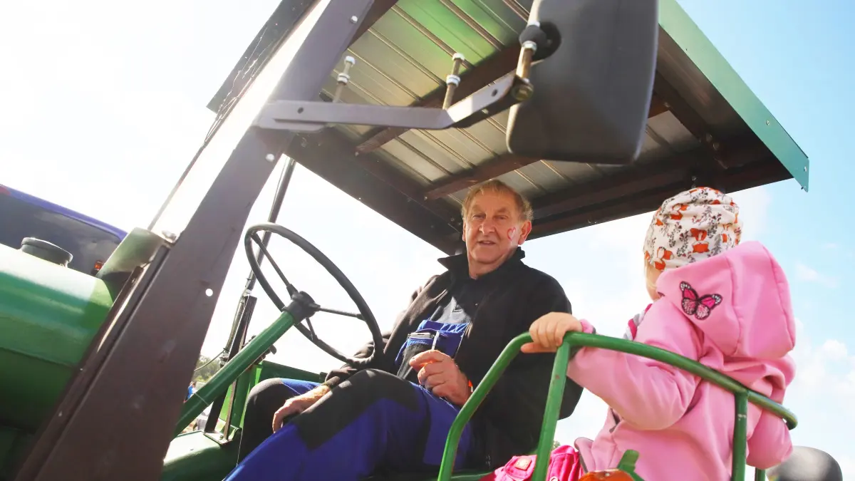 Eberhard Kochan auf seinem alten Traktor. Er ist eines von rund 15 Kartoffeltaxis beim 16. Kartoffelbuddeln 2024 in Storkow.