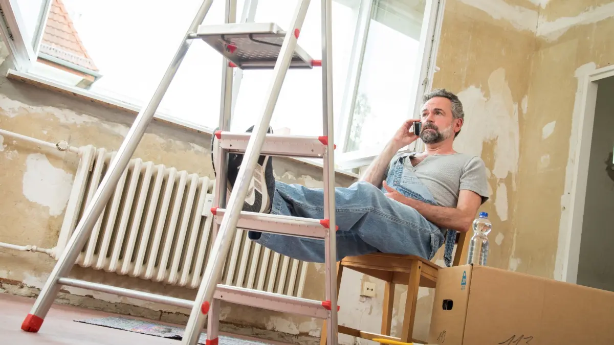 Ein Mann sitzt auf einem Stuhl und telefoniert: ILLUSTRATION - Wer wegen einer dringenden Reparatur einen Handwerker organisieren muss, darf das nicht einfach so während der Arbeitszeit tun. (zu dpa: «Muss mein Chef mich für dringende Reparaturen freistellen?») Foto: Christin Klose/dpa-tmn - Honorarfrei nur für Bezieher des dpa-Themendienstes +++ dpa-Themendienst +++