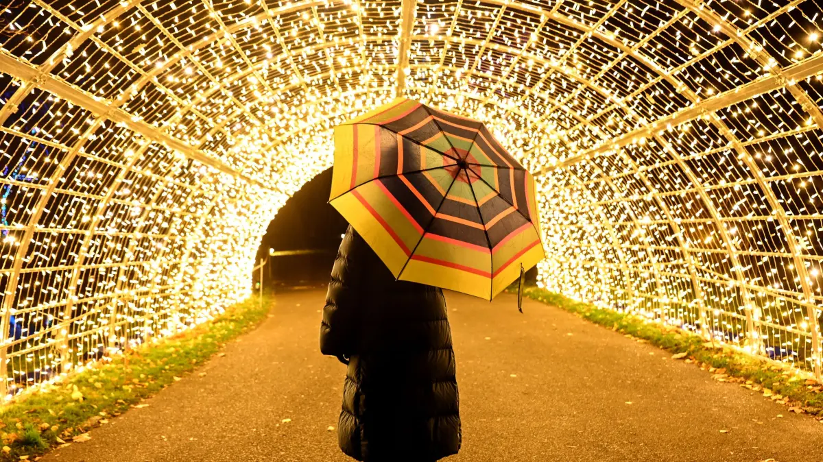 Eine junge Frau geht durch eine Lichtinstallation anlässlich der Attraktion "Weihnachten 2022 im Tierpark". Vom 18. November 2022 bis 15. Januar 2023 können Besucher sich auf einem erleuchteten Rundweg mit Projektionen und Millionen von Lichtern in weihnachtliche Stimmung versetzen. (Wiederholung mit verändertem Bildausschnitt) +++ dpa-Bildfunk +++