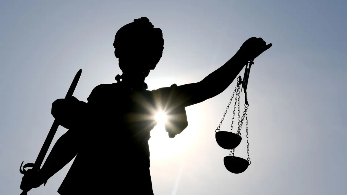 Justicia im Gegenlicht: ARCHIV - 25.02.2019, Hessen, Darmstadt: Das Jugendamt muss das Familiengericht informieren, wenn Untersuchungen versäumt werden, aber das Gericht muss dann prüfen, ob Maßnahmen erforderlich sind. (zu dpa: «Eltern aus Sekte «Zwölf Stämme» haben Sorgerecht zurück») Foto: Arne Dedert/dpa +++ dpa-Bildfunk +++