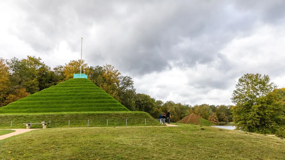 Herbst-Stimmung im Branitzer Park: 13.10.2024, Brandenburg, Cottbus: Spaziergänger laufen im Branitzer Park an der Landpyramide vorbei. Im Hintergrund ist die Seepyramide zu sehen. Foto: Frank Hammerschmidt/dpa - Honorarfrei nur für Bezieher des Dienstes ZB-Funkregio Ost +++ ZB-FUNKREGIO OST +++