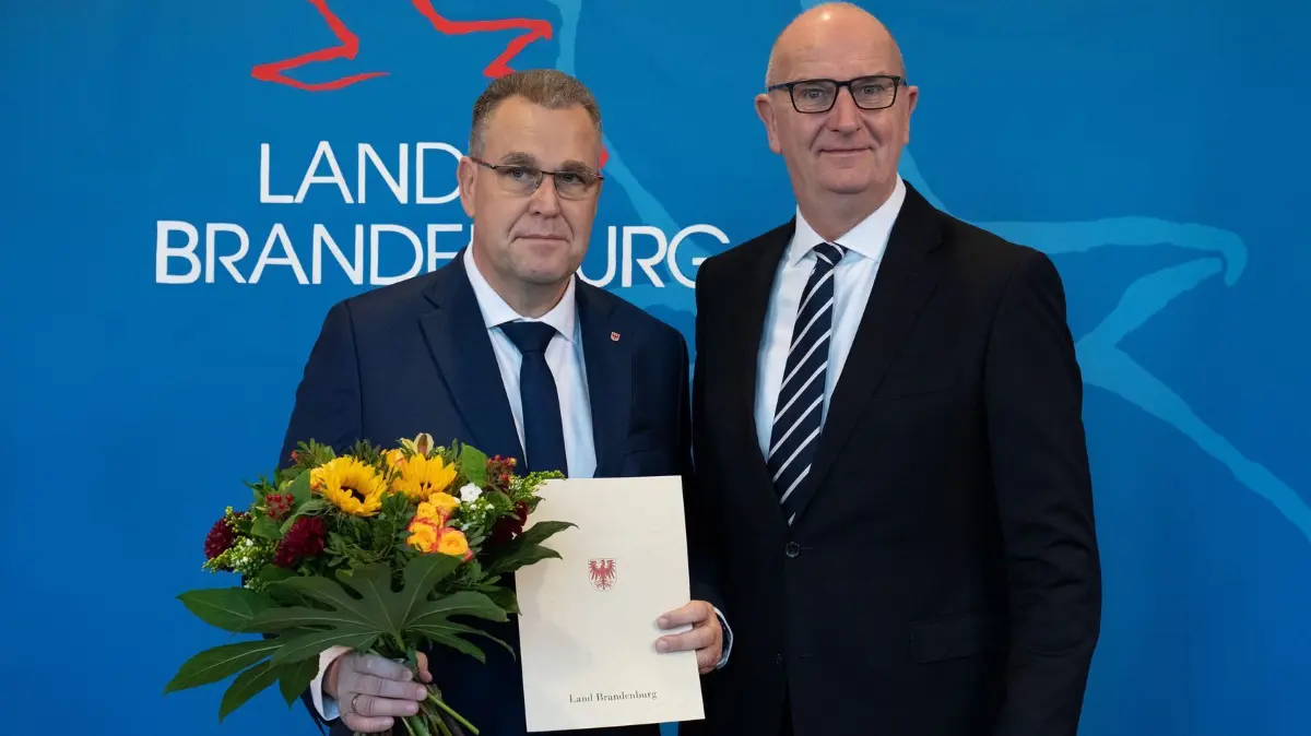 Ministerpräsident Woidke übergibt Dankesurkunden: 17.10.2024, Brandenburg, Potsdam: Dietmar Woidke (r, SPD), Ministerpräsident von Brandenburg, hat eine Dankesurkunde und Blumen an Rainer Genilke (CDU), Brandenburger Minister für Infrastruktur und Landesplanung, übergeben. Bis zur Wahl und Vereidigung einer neuen Landesregierung bleibt die Landesregierung im Amt und agiert als „geschäftsführende Regierung“. Foto: Soeren Stache/dpa +++ dpa-Bildfunk +++