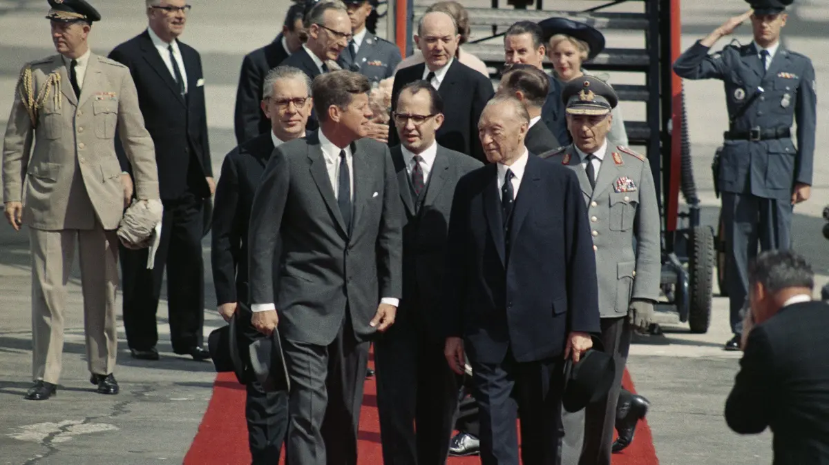 ARCHIV - Der amerikanische Präsident John F. Kennedy (l) nach seiner Ankunft am 23. Juni 1963 auf dem Flughafen Köln-Bonn mit Bundeskanzler Konrad Adenauer (r). Kennedy sprach während seines Staatsbesuchs in der Bundesrepublik bei einer Visite in Berlin (West) die berühmten Worte "Ich bin ein Berliner". (zu dpa:"Schlitzohriger Revolutionär - Vor 50 Jahren starb Adenauer" vom 12.04.2017) Foto: Alfred Hennig/dpa +++ dpa-Bildfunk +++