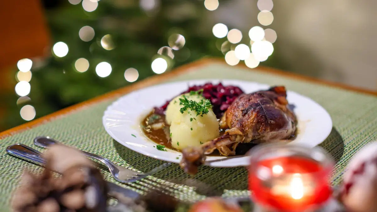 Weihnachten - Gänsebraten: ARCHIV - 13.12.2021, Sachsen, Wermsdorf: Eine Portion Gänsekeule mit Rotkraut und Klößen steht auf einem Tisch im Restaurant der Gänsezucht Eskildsen. (zu dpa: «Gänsepreise dieses Jahr stabil - Importe deutlich billiger») Foto: Jan Woitas/dpa-Zentralbild/dpa +++ dpa-Bildfunk +++