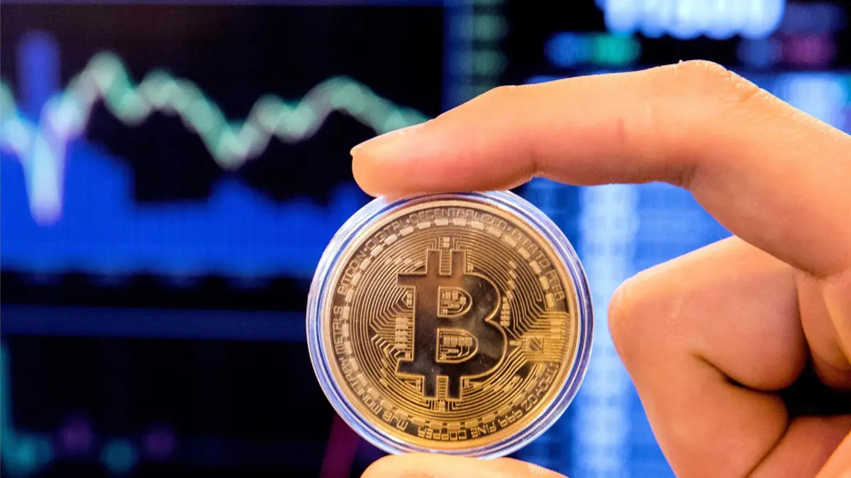 An Israeli holds a visual representation of the digital cryptocurrency Bitcoin, at the "Bitcoin Change" shop in the Israeli city of Tel Aviv on January 17, 2018.
At the end of 2017 Israel Securities Authority said it was moving to ban trading in cryptocurrency-based companies on the Tel Aviv market until transactions involving digital coins are legally regulated. / AFP PHOTO / JACK GUEZ