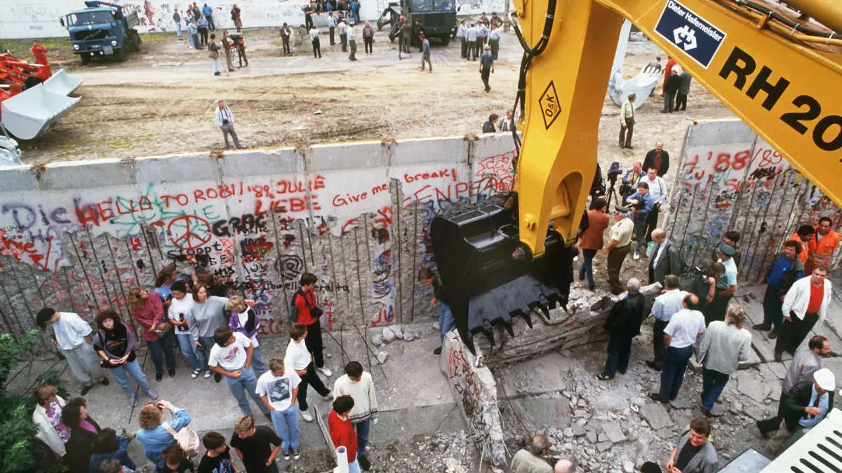Ein Schaufelbagger reißt die Berliner Mauer an der Bernauer Straße im West-Berliner Bezirk Wedding ein - Soldaten der Grenztruppen der DDR bauen im Osten Teile der Mauer ab. (zu «Vor 30 Jahren: Die Berliner Mauer kommt weg - Wunderkerzen») +++ dpa-Bildfunk +++