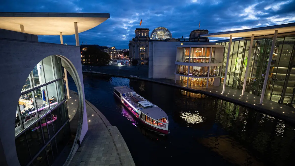 Reichstagsgebäude am Abend: 13.11.2024, Berlin: Ein Schiff fährt am Abend auf der Spree zwischen dem Marie-Elisabeth-Lüders-Haus, dem Paul-Löbe-Haus und den Reichstagsgebäude entlang. Foto: Hannes P. Albert/dpa +++ dpa-Bildfunk +++
