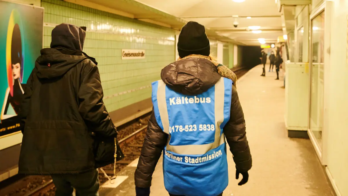 Eine Kältebus-Mitarbeiterin läuft mit einem Obdachlosen im U-Bahnhof Turmstraße in Berlin den Bahnsteig entlang. Die Helfer bringen warme Getränke, Schlafsäcke oder rufen auch Kollegen für den Transport in eine Unterbringung.