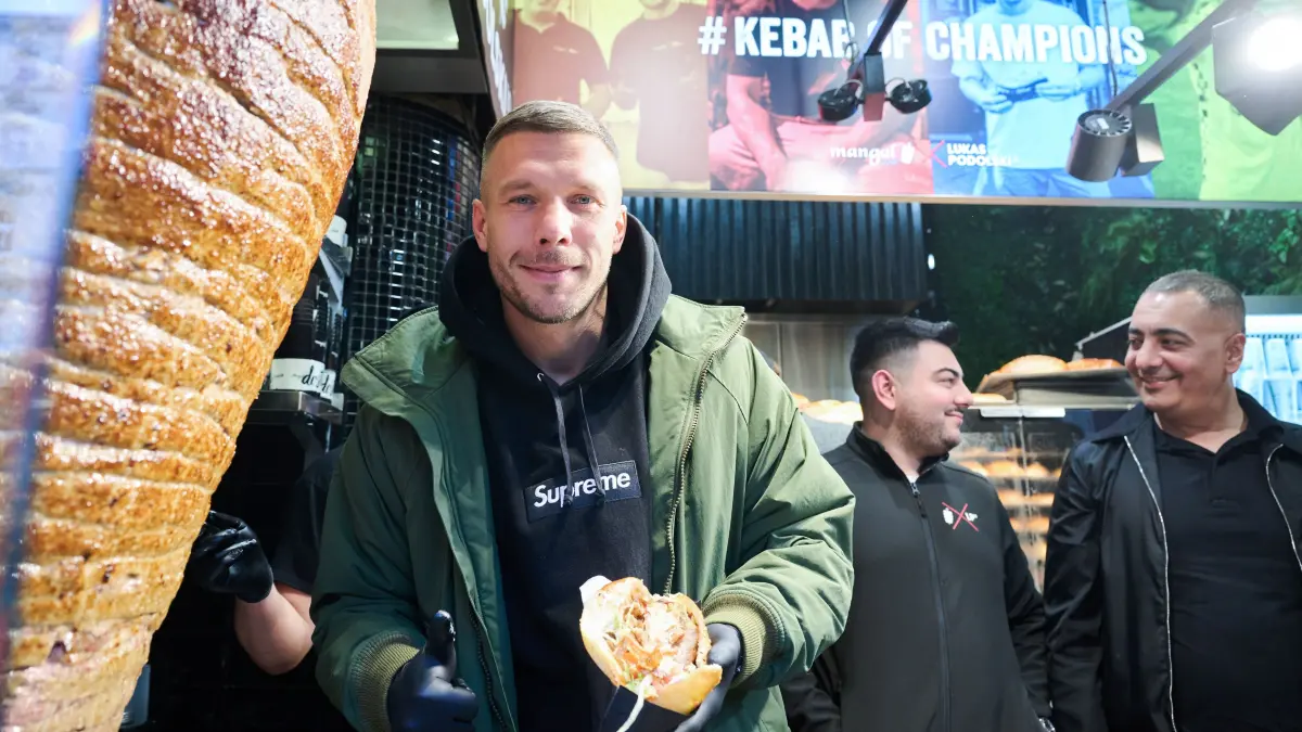 Lukas Podolski, ehemaliger Fußballprfoi und Unternehmer, zeigt seinen ersten Döner während der Eröffnung seines Döner-Imbiss. +++ dpa-Bildfunk +++