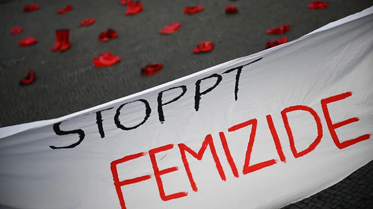 Internationaler Tag für die Beseitigung von Gewalt gegen Frauen: 25.11.2024, Berlin: Ein Banner mit der Aufschrift «Stoppt Femizide» hängt vor roten Schuhen, die anlässlich des Internationalen Tags für die Beseitigung von Gewalt gegen Frauen vor dem Rathaus Tiergarten stehen. Die Aktion ist angelehnt an das Projekt «Zapatos Rojos» (dt. Rote Schuhe) der mexikanischen Künstlerin Chauvet, die damit gegen Gewalt an Frauen protestiert. Foto: Sebastian Christoph Gollnow/dpa +++ dpa-Bildfunk +++