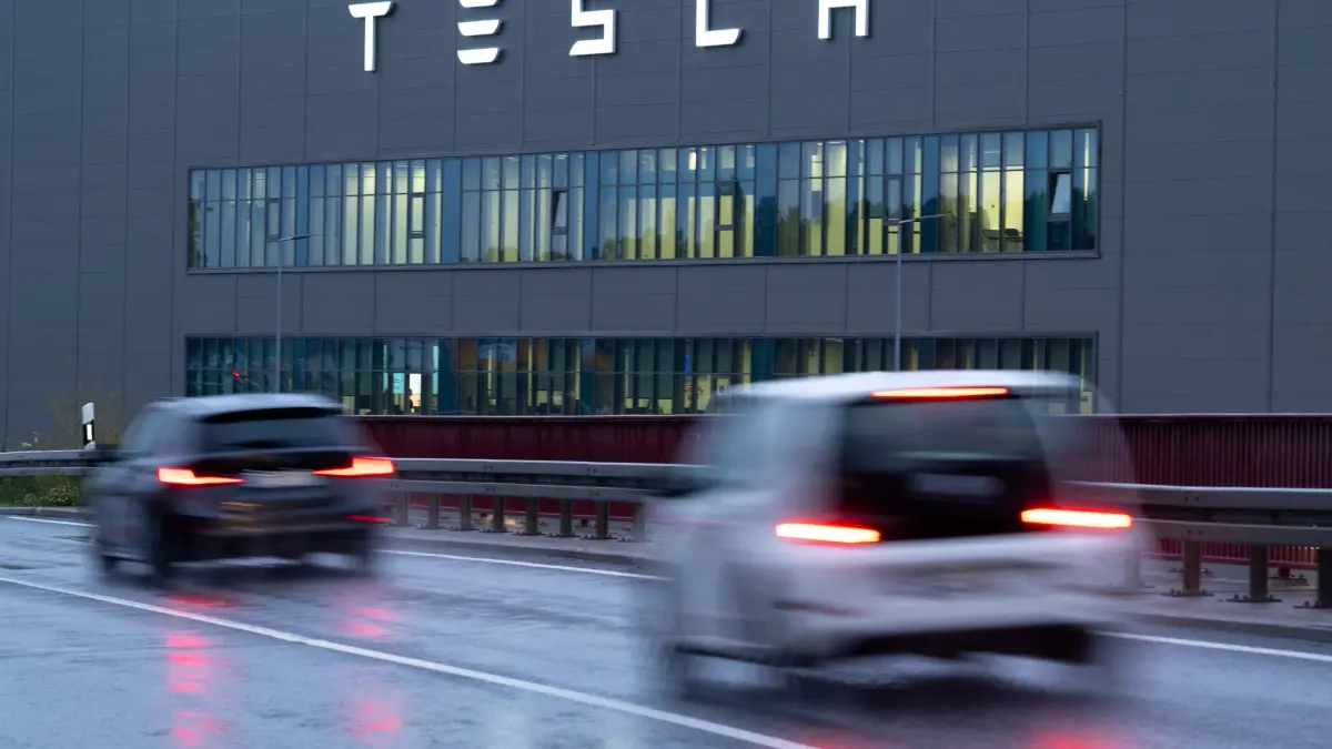 Autos fahren auf der Straße L38 an der Tesla Gigafactory in Grünheide vorbei.