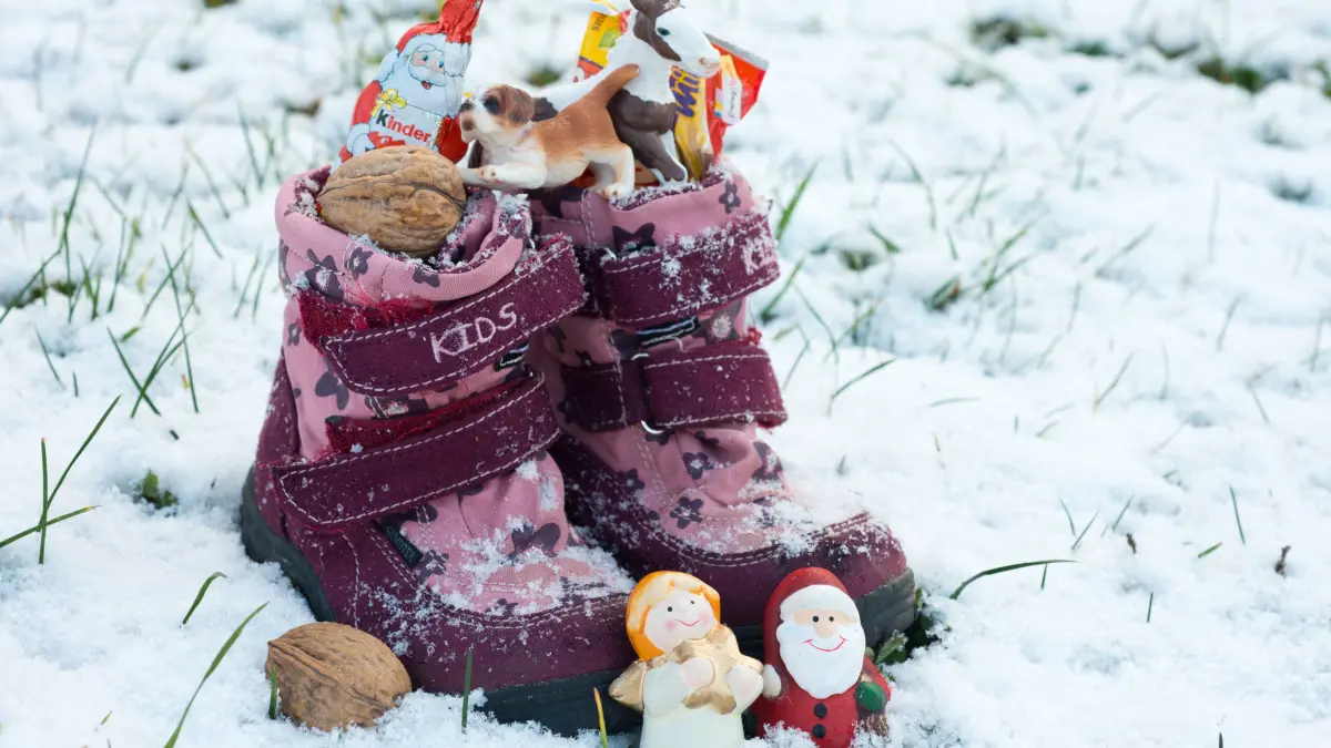 ILLUSTRATION - Ein paar Kinderschuhe stehen gefüllt mit Nüssen, Schokolade und kleinen Geschenken am 05.12.2012 im Schnee auf einer Wiese in Frankfurt (Oder) (Brandenburg). Am 6.12. ist Nikolaustag. Seit dem elften Jahrhundert zieht Nikolaus traditionell am 6. Dezember durchs Land, um brave Kinder zu beschenken. Vielerorts stellen sie dazu bereits am Vorabend ihre Stiefel vor die Tür. Sankt Nikolaus füllt die Schuhe in der Nacht mit Äpfeln, Nüssen und Süßigkeiten. Als historisches Vorbild für den Nikolaus gilt der Bischof von Myra, der im vierten Jahrhundert lebte und als Schutzpatron der Kinder verehrt wird. Foto: Patrick Pleul/dpa ++ +++ dpa-Bildfunk +++