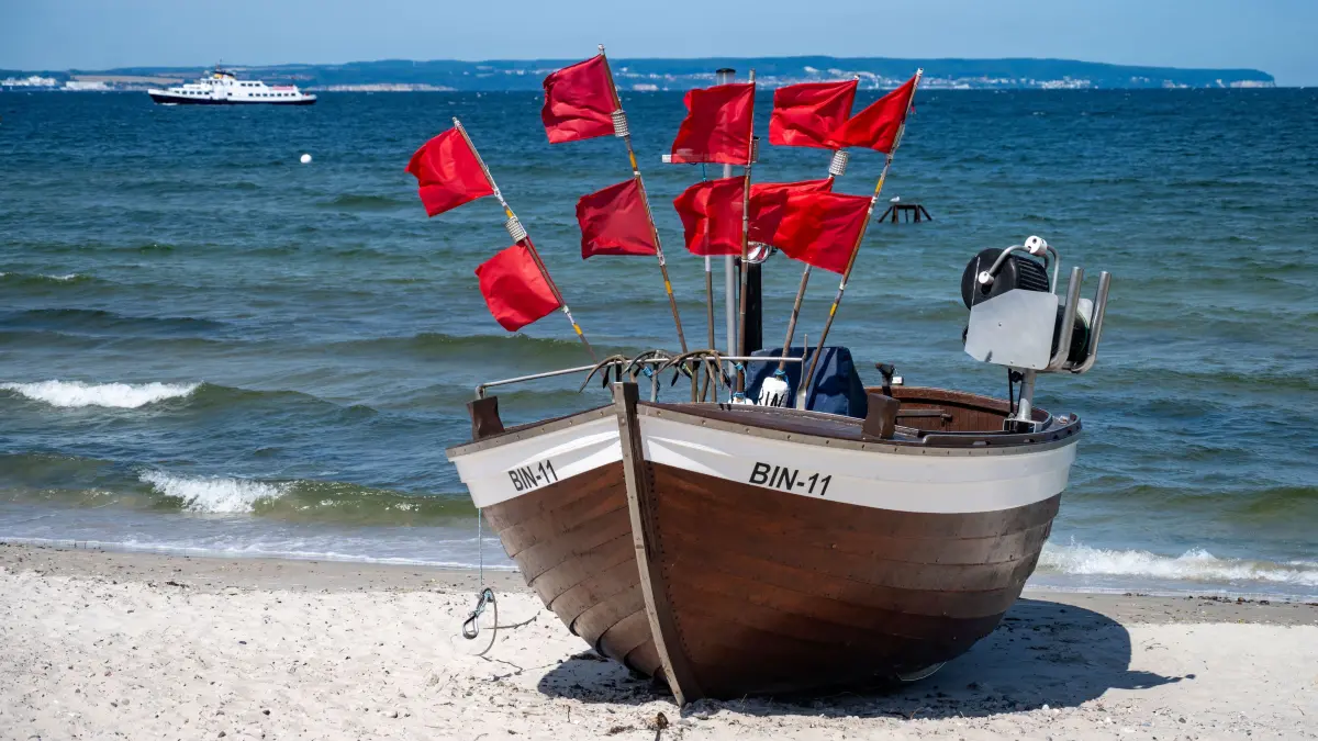 Ein Fischerboot steht bei sonnigem Wetter am Strand des Ostseebades Binz auf der Insel Rügen. +++ dpa-Bildfunk +++