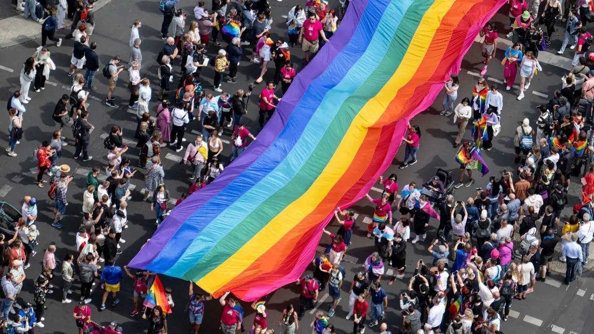 Christopher Street Day Berlin: ARCHIV - 22.07.2023, Berlin: Menschen ziehen auf der 45. Berlin Pride-Parade zum Christopher Street Day (CSD) mit einer überdimensionalen Regenbogenfahne durch die Stadt. Der Berliner CSD ist eine der größten Veranstaltungen der lesbischen, schwulen, bisexuellen, trans-, intergeschlechtlichen und queeren (LGBTIQ) Community in Europa. (zu dpa: «Land startet Kampagne gegen queerfeindliche Gewalt») Foto: Fabian Sommer/dpa +++ dpa-Bildfunk +++