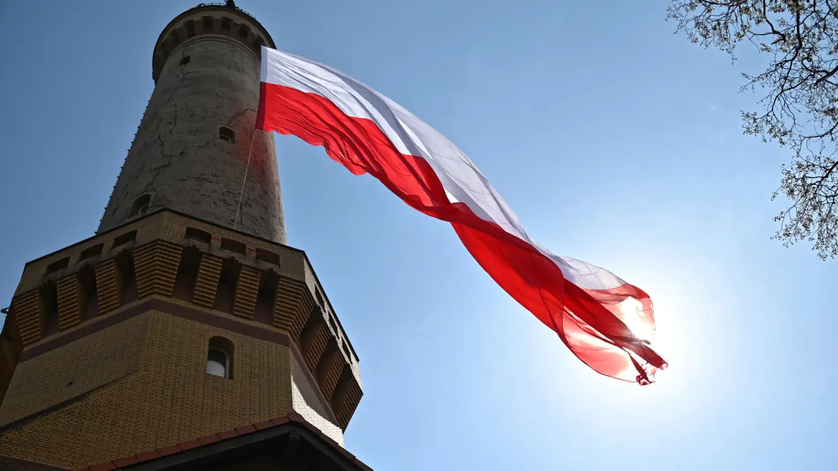 Eine riesige polnische Nationalflagge weht an einem Leuchtturm in Swinemünde.