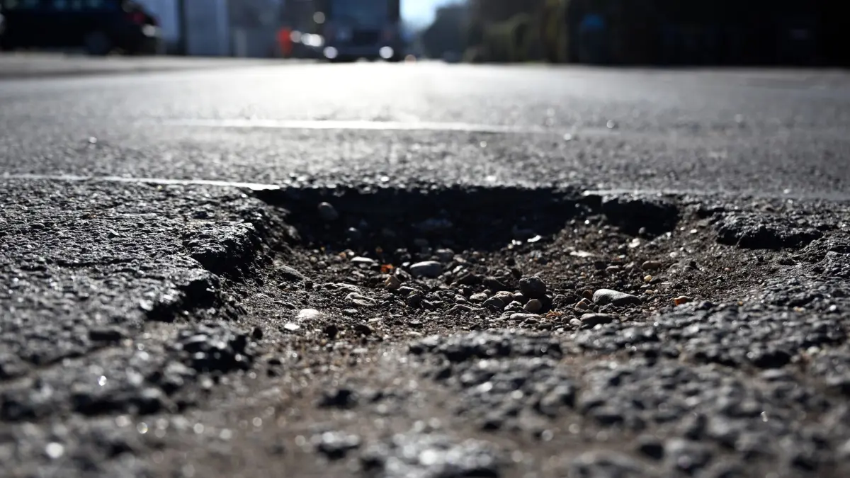 Marode Straßeninfrastruktur: ARCHIV - 08.02.2023, Nordrhein-Westfalen, Stadt: Ein Schlagloch hat sich in einer Straße gebildet. Der Hauptverband der Bauindustrie (HDB) fordert eine Pkw-Maut und warnt angesichts maroder Straßen vor einem Verkehrskollaps. (zu dpa: «Bauindustrie fordert Pkw-Maut gegen «Verkehrskollaps»») Foto: Federico Gambarini/dpa +++ dpa-Bildfunk +++