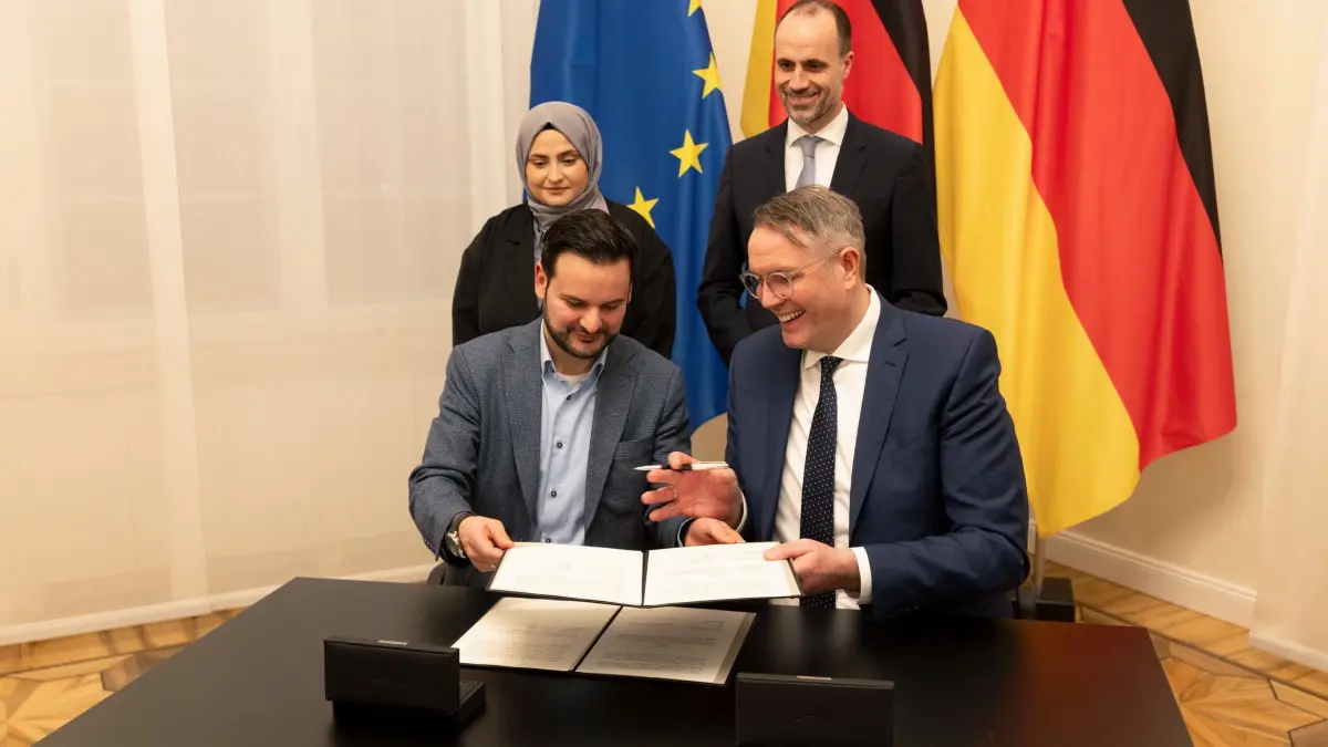 Land und islamischen Religionsgemeinschaften schließen Verträge: 20.12.2024, Rheinland-Pfalz, Mainz: Alexander Schweitzer (vorne rechts, SPD), Ministerpräsident von Rheinland-Pfalz, und Clemens Hoch (SPD, hinten rechts) Minister für Wissenschaft und Gesundheit in Rheinland-Pfalz, (beide SPD) unterzeichnen Verträge mit Cihan Sen (vorne links) und Geschäftsführerin Canan Üstündag von Ditib Rheinland-Pfalz. Foto: Helmut Fricke/dpa +++ dpa-Bildfunk +++