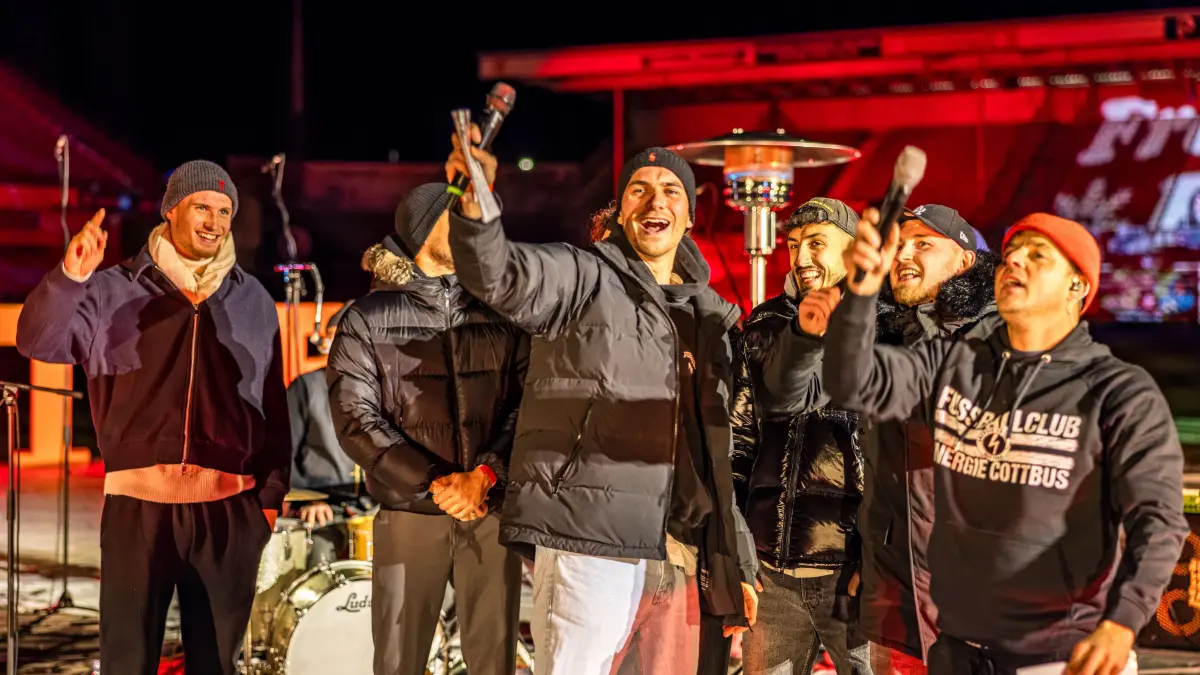 Weihnachtssingen beim FC Energie Cottbus: Spieler des FC Energie Cottbus und Alexander Knappe (r) singen vor der Nordwand im LEAG Energie Stadion beim Weihnachtssingen des FC Energie Cottbus.