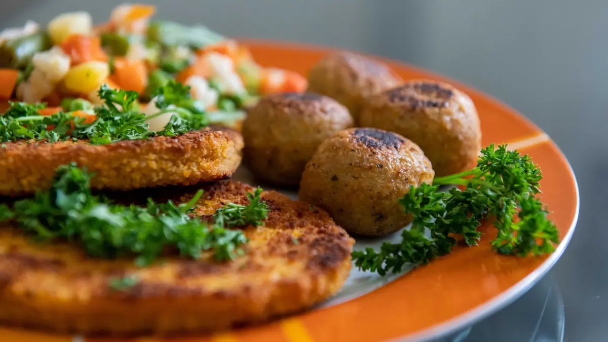 Fleischlose Ernährung: ARCHIV - 07.02.2022, Baden-Württemberg, Rottweil: ILLUSTRATION - Falafel, vegane Schnitzel und Gemüse liegen auf einem Teller in einer Küche. Etwa zwölf Prozent der Menschen in Deutschland ernähren sich nach einer repräsentativen Umfrage mittlerweile vegetarisch oder vegan. (zu dpa: «Trotz Lokal-Schließungen: Veggie behauptet sich») Foto: Silas Stein/dpa +++ dpa-Bildfunk +++