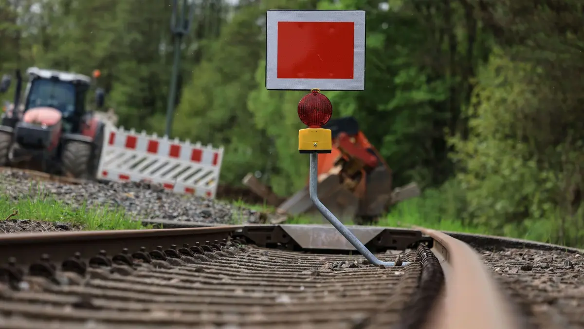 Aufbauarbeiten Bahnstrecke Köln - Trier: ARCHIV - 09.05.2023, Nordrhein-Westfalen, Kall: Ein Schild steht am Streckenabschnitt der Bahnstrecke Köln - Trier bei Kall. In Euskirchen ist fast ein halbes Jahr lang Endstation für Züge in Richtung Trier. (zu dpa: «Eifelbahn wird elektrisch - Vollsperrung für Bauarbeiten») Foto: Oliver Berg/dpa +++ dpa-Bildfunk +++