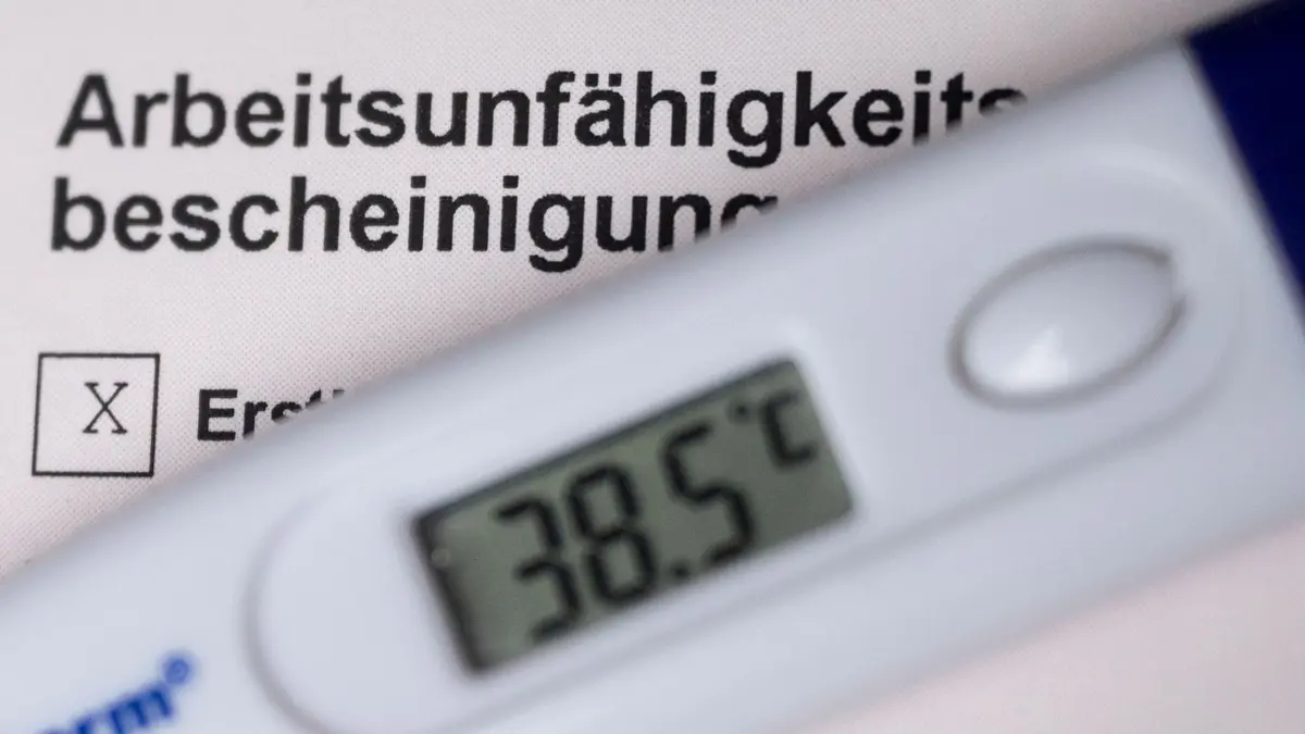 ARCHIV - 19.10.2020, Baden-Württemberg, Stuttgart: ILLUSTRATION - Ein Fieberthermometer liegt auf einer Arbeitsunfähigkeitsbescheinigung (gestellte Szene). Am 31. März läuft eine Corona-Sonderregelung zu telefonischen Krankschreibungen aus. Hausärzte und Verbraucherschützer fordern eine Beibehaltung der telefonischen Krankschreibung ohne Arztbesuch. (zu dpa «Hausärzte: Ohne telefonische Krankschreibung «geht es nicht mehr»») Foto: Marijan Murat/dpa +++ dpa-Bildfunk +++