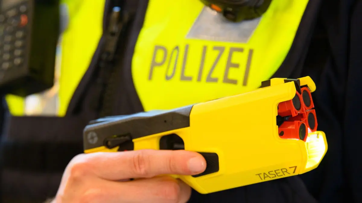 ARCHIV - 30.06.2021, Brandenburg, Potsdam: Ein Polizeibeamter hält im Rahmen der Pressekonferenz des Polizeipräsidenten einen Taser 7 in der Hand. (zu dpa: «Baden-Württemberg will keine Taser für Streifenbeamte») Foto: Soeren Stache/dpa-Zentralbild/dpa +++ dpa-Bildfunk +++
