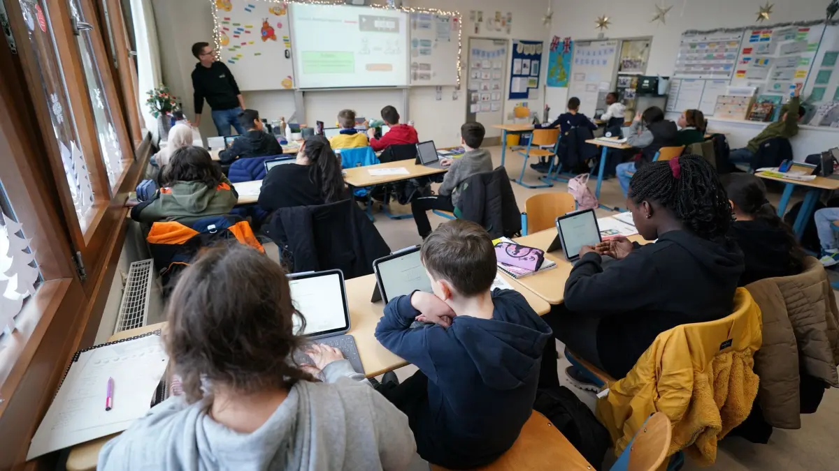 Digitale Kluft zwischen weiterführenden Schulen: ARCHIV - 04.12.2023, Hamburg: Mathe-Lehrer Tobias Weidenhöffer-Griese (hinten l) leitet den digitalen Mathe-Unterricht in der Klasse 5f in der Lessing-Stadtteilschule in Harburg-Wilstorf. (zu dpa: «Deutliche digitale Kluft an Hamburgs Schulen») Foto: Marcus Brandt/dpa +++ dpa-Bildfunk +++