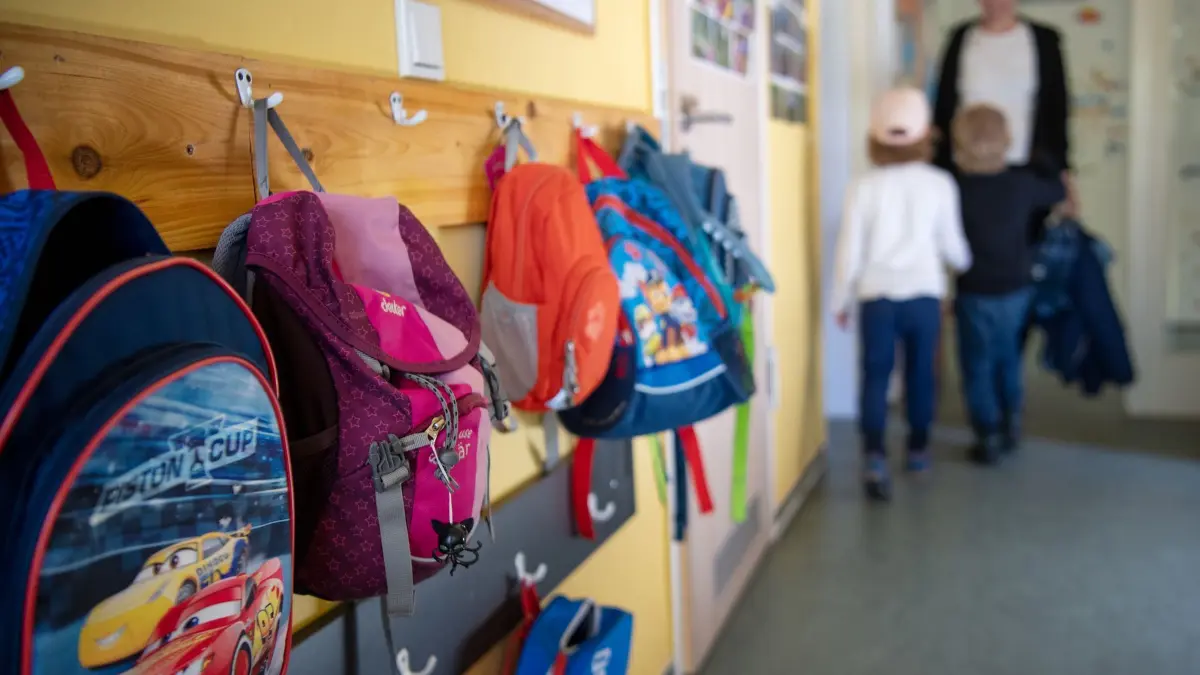 Eltern berichten von häufigen Betreuungsengpässen: ARCHIV - 24.04.2019, Brandenburg, Wandlitz: Als Folge vermehrter Geburten mussten auch die Kommunen mehr Plätze in Kindergärten schaffen. Im Bild: Kinderrucksäcke hängen im Eingangsbereich einer Kita (zu dpa: «Umfrage: Eltern häufig von Kita- und Schulschließungen betroffen») Foto: Monika Skolimowska/dpa-Zentralbild/dpa +++ dpa-Bildfunk +++