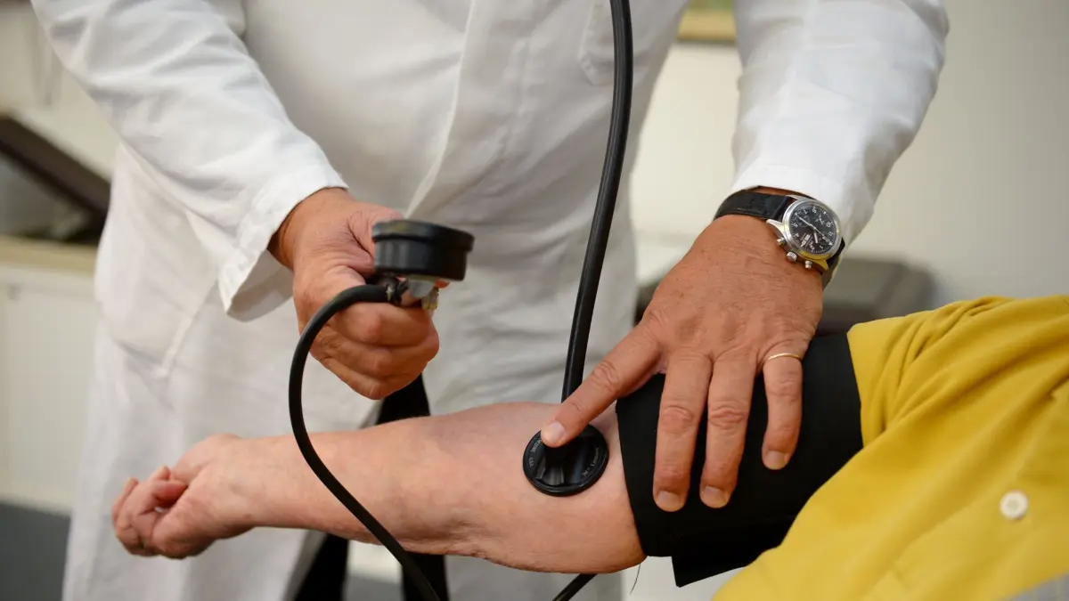 ARCHIV - 18.09.2013, Baden-Württemberg, Stuttgart: Ein Hausarzt misst in seiner Praxis in Stuttgart einer Patientin den Blutdruck. Der Ärztemangel macht Medien und Bürgern große Sorgen. (zu dpa: «Finanzielle Erleichterungen für Hausärzte») Foto: Bernd Weißbrod/dpa +++ dpa-Bildfunk +++