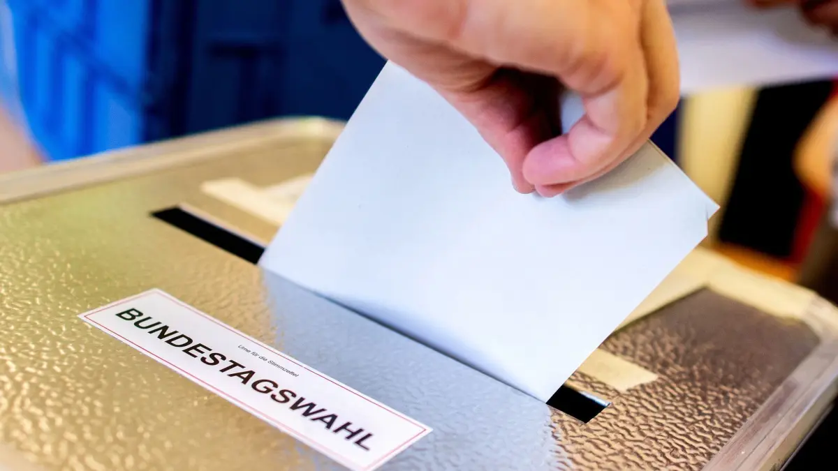 ARCHIV - 26.09.2021, Berlin: Ein Wähler wirft in einem Wahllokal seinen Stimmzettel für die Bundestagswahl 2021 in eine Wahlurne. (zu dpa: «Warum Scholz, Merz & Co. auf vielen Stimmzetteln fehlen») Foto: Hauke-Christian Dittrich/dpa +++ dpa-Bildfunk +++