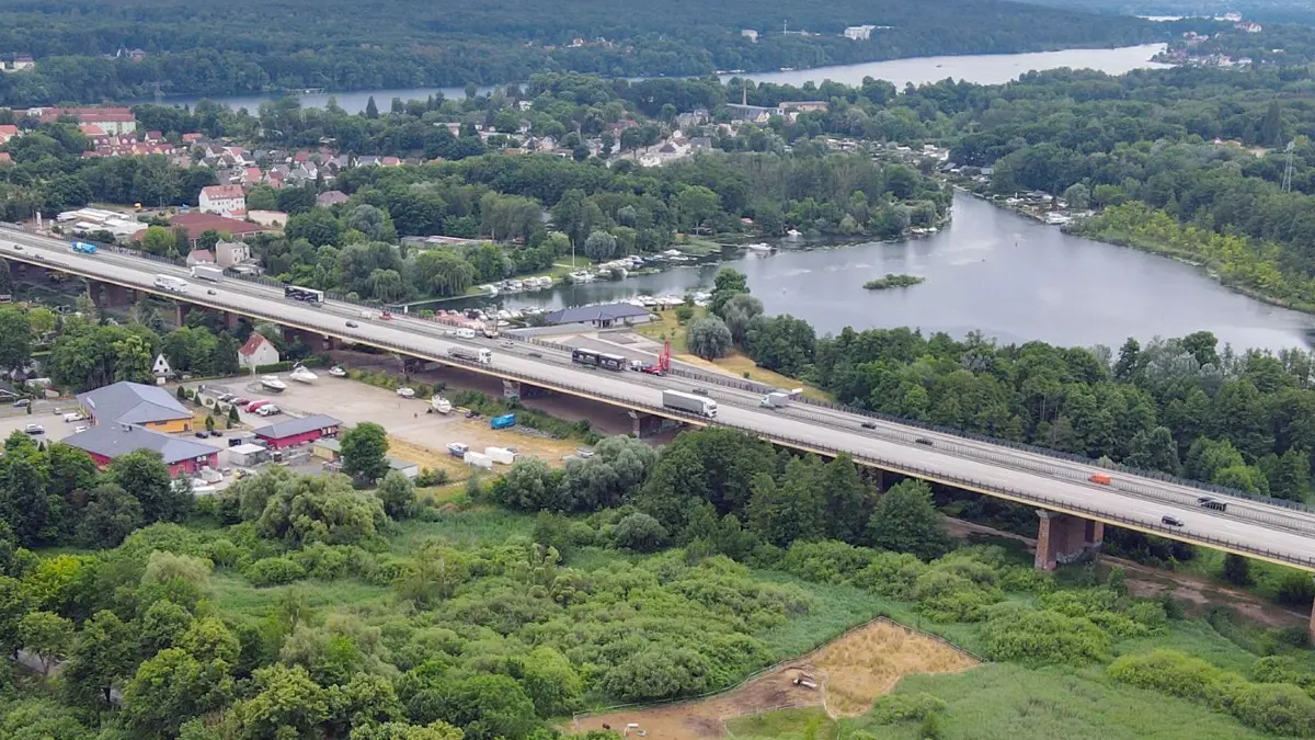Brandenburg längste Autobahnbrücke soll erneuert werden: ARCHIV - 22.06.2021, Brandenburg, Rüdersdorf: Die Mühlenfließbrücke der Autobahn A10 am östlichen Berliner Ring (Luftaufnahme mit einer Drohne). Vor Ort gab es am selben Tag eine Besichtigung der Autobahn GmbH des Bundes. Dieses 742 Meter lange Bauwerk ist die längste Autobahnbrücke im Land Brandenburg. Die Fundamente und Bögen stammen aus dem 1930er Jahren. Stahlsegmente wurden in den 1990er Jahren erneuert. Es wird derzeit an einem kompletten Neubau der Brücke geplant. Diese soll spätestens in zehn Jahren fertig gebaut sein. Täglich fahren etwa 60.000 Fahrzeuge über die Mühlenfließbrücke. In ganz Deutschland gibt es rund 27.000 Autobahnbrücken. (zu dpa: «Zauneidechsen müssen wegen Brücken-Neubaus umziehen») Foto: Patrick Pleul/dpa-Zentralbild/dpa +++ dpa-Bildfunk +++