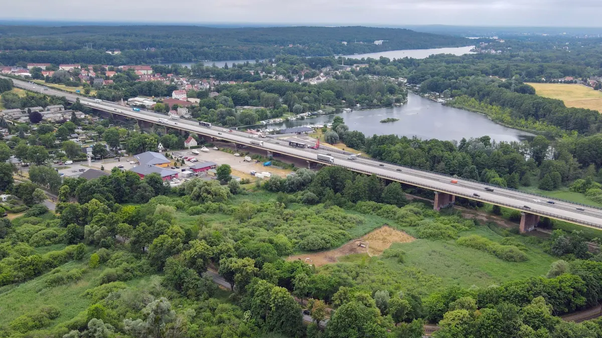 Brandenburg längste Autobahnbrücke soll erneuert werden: ARCHIV - 22.06.2021, Brandenburg, Rüdersdorf: Die Mühlenfließbrücke der Autobahn A10 am östlichen Berliner Ring (Luftaufnahme mit einer Drohne). Vor Ort gab es am selben Tag eine Besichtigung der Autobahn GmbH des Bundes. Dieses 742 Meter lange Bauwerk ist die längste Autobahnbrücke im Land Brandenburg. Die Fundamente und Bögen stammen aus dem 1930er Jahren. Stahlsegmente wurden in den 1990er Jahren erneuert. Es wird derzeit an einem kompletten Neubau der Brücke geplant. Diese soll spätestens in zehn Jahren fertig gebaut sein. Täglich fahren etwa 60.000 Fahrzeuge über die Mühlenfließbrücke. In ganz Deutschland gibt es rund 27.000 Autobahnbrücken. (zu dpa: «Zauneidechsen müssen wegen Brücken-Neubaus umziehen») Foto: Patrick Pleul/dpa-Zentralbild/dpa +++ dpa-Bildfunk +++